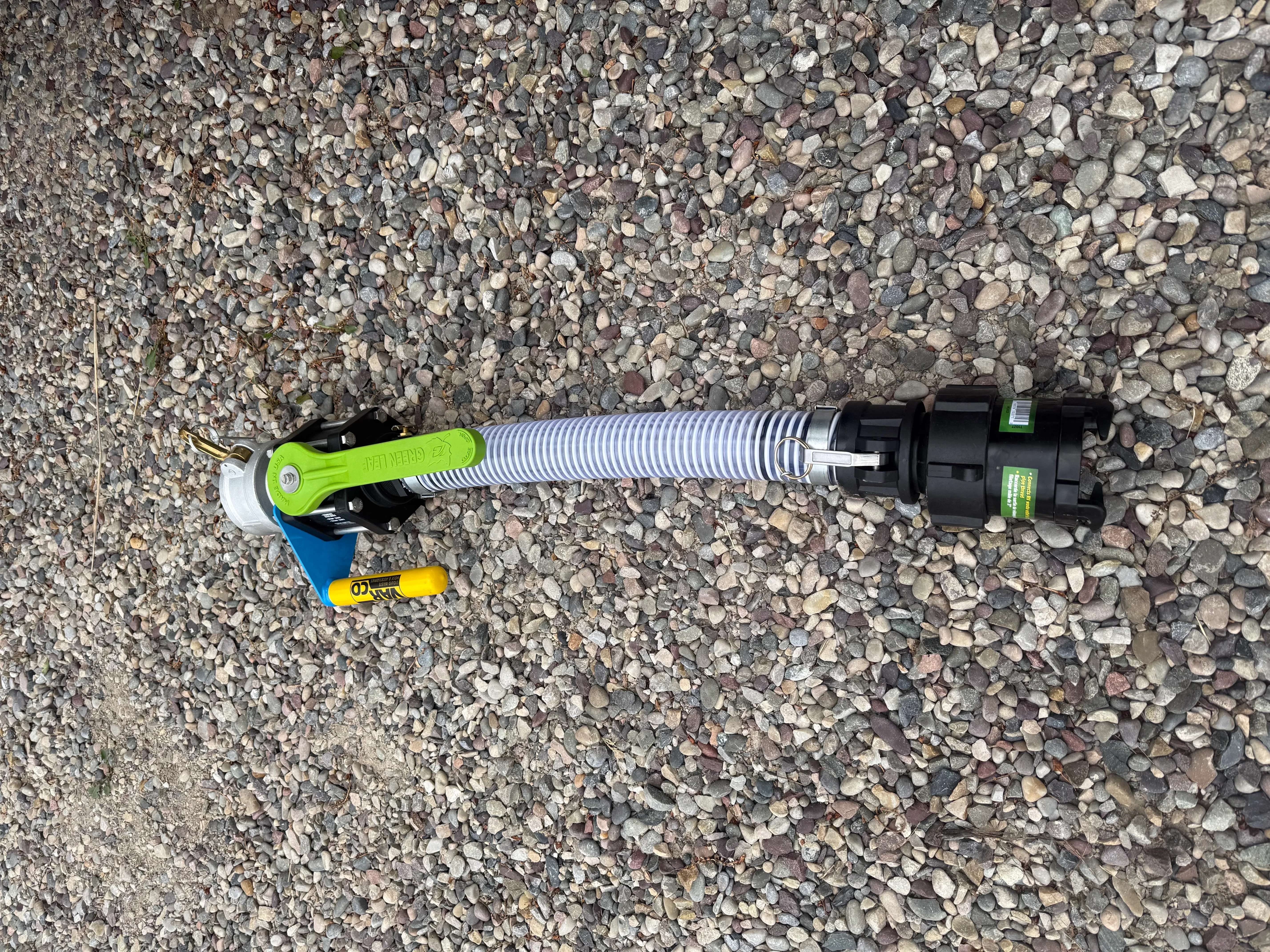 Green ball valve with corrugated piping and black septic distribution components on gravel base
