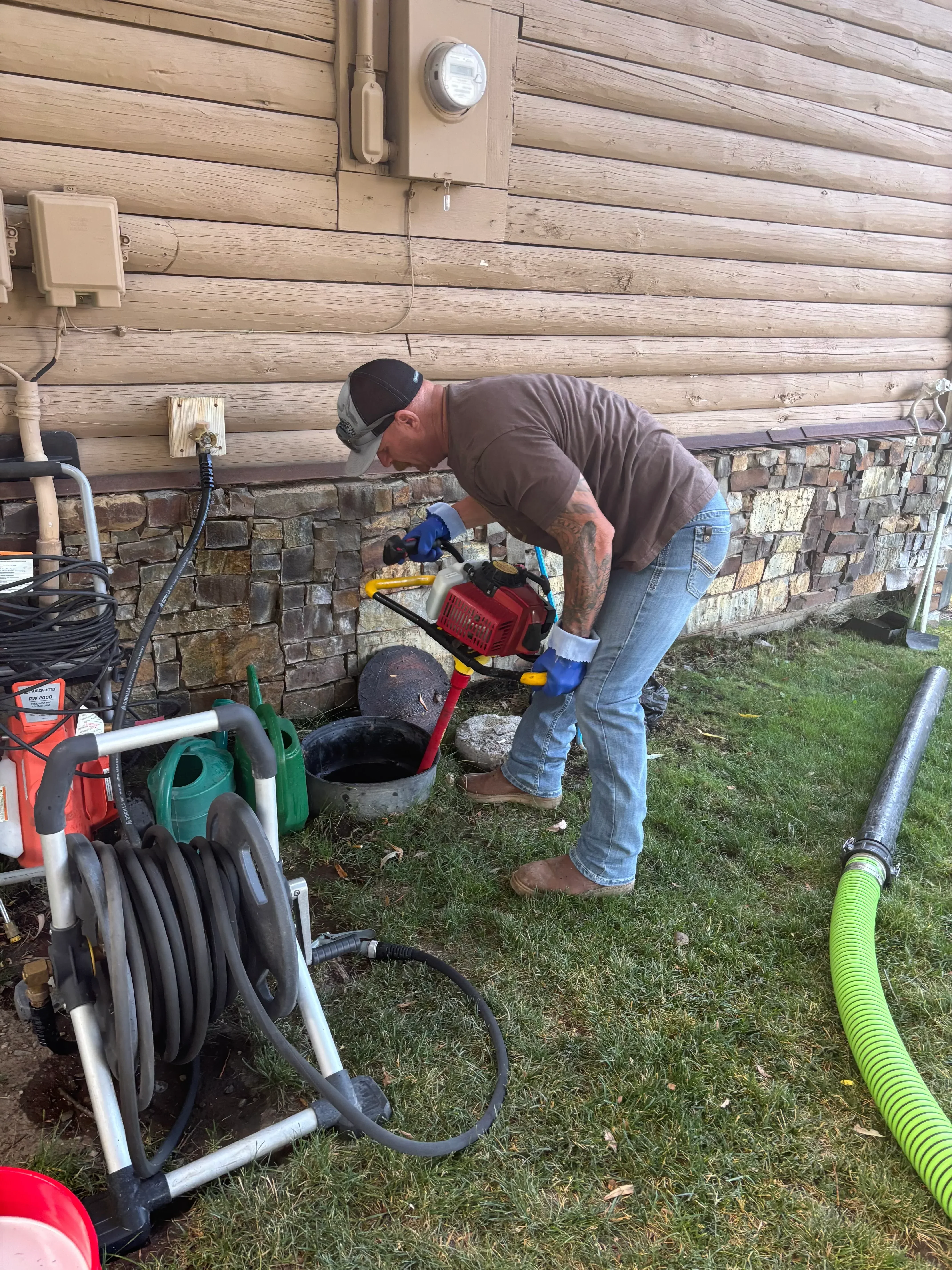 Septic technician working on residential septic tank system with professional equipment and tools